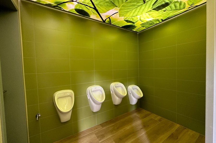 Holzfußboden und grüne Wandfliesen in der Toilettenanlage WC der Sinne im Sauerlandpark Hemer